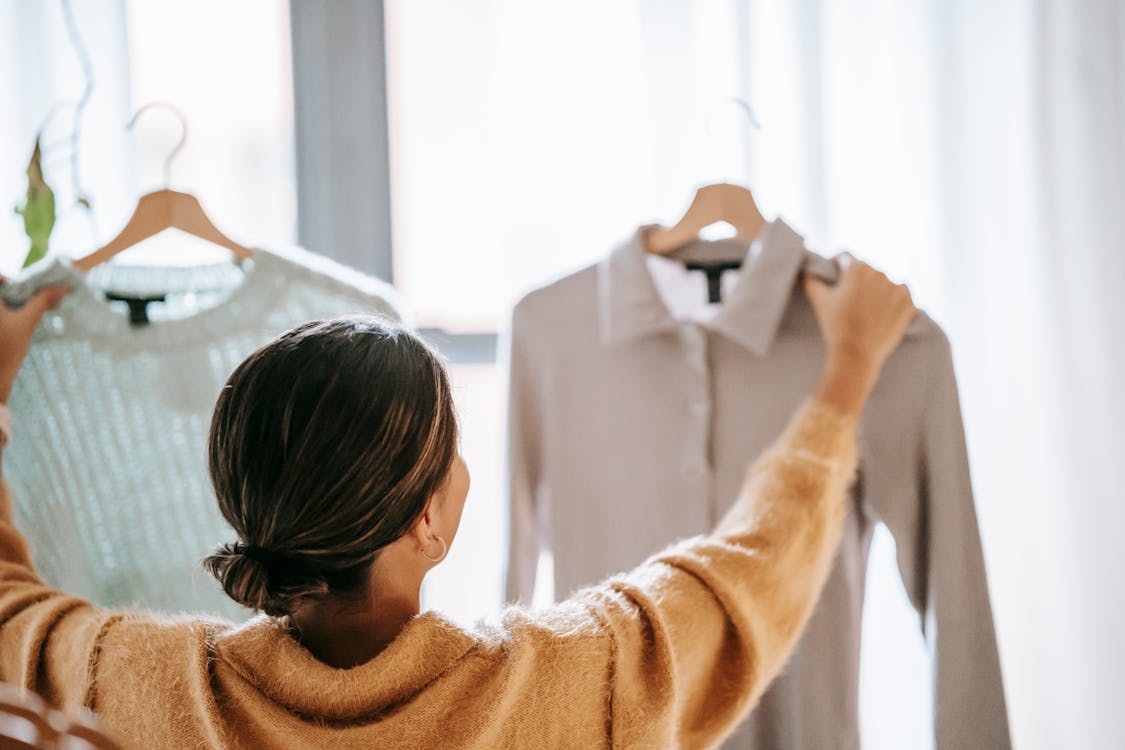 Free Anonymous woman choosing clothes in store Stock Photo