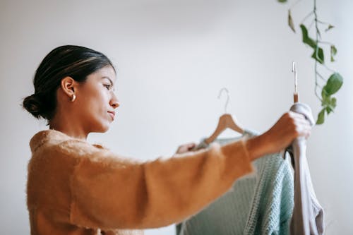 Focused woman choosing clothes at home
