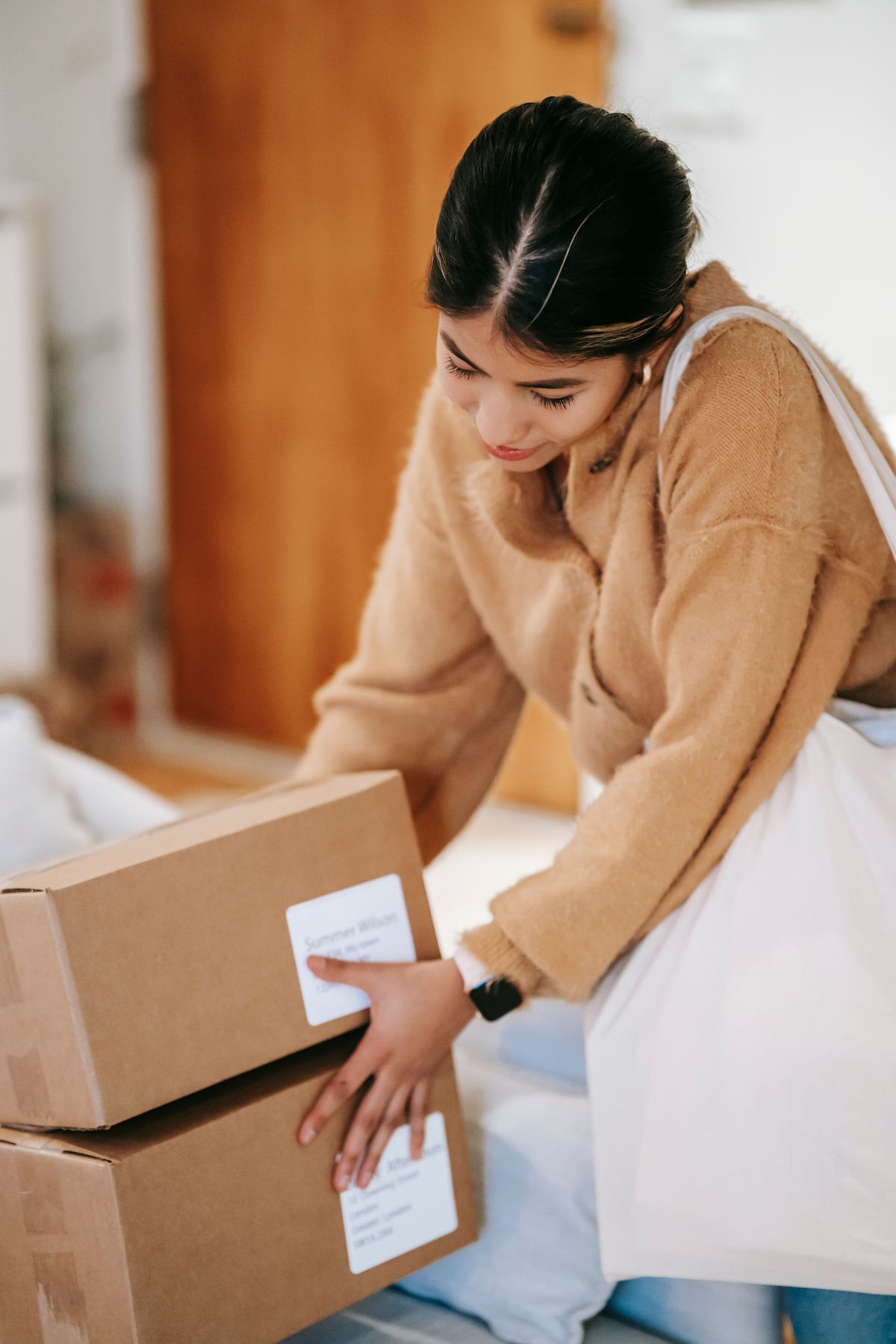 Customer handling labeled cardboard parcels at home