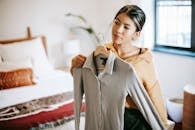 Asian woman trying on clothes in bedroom