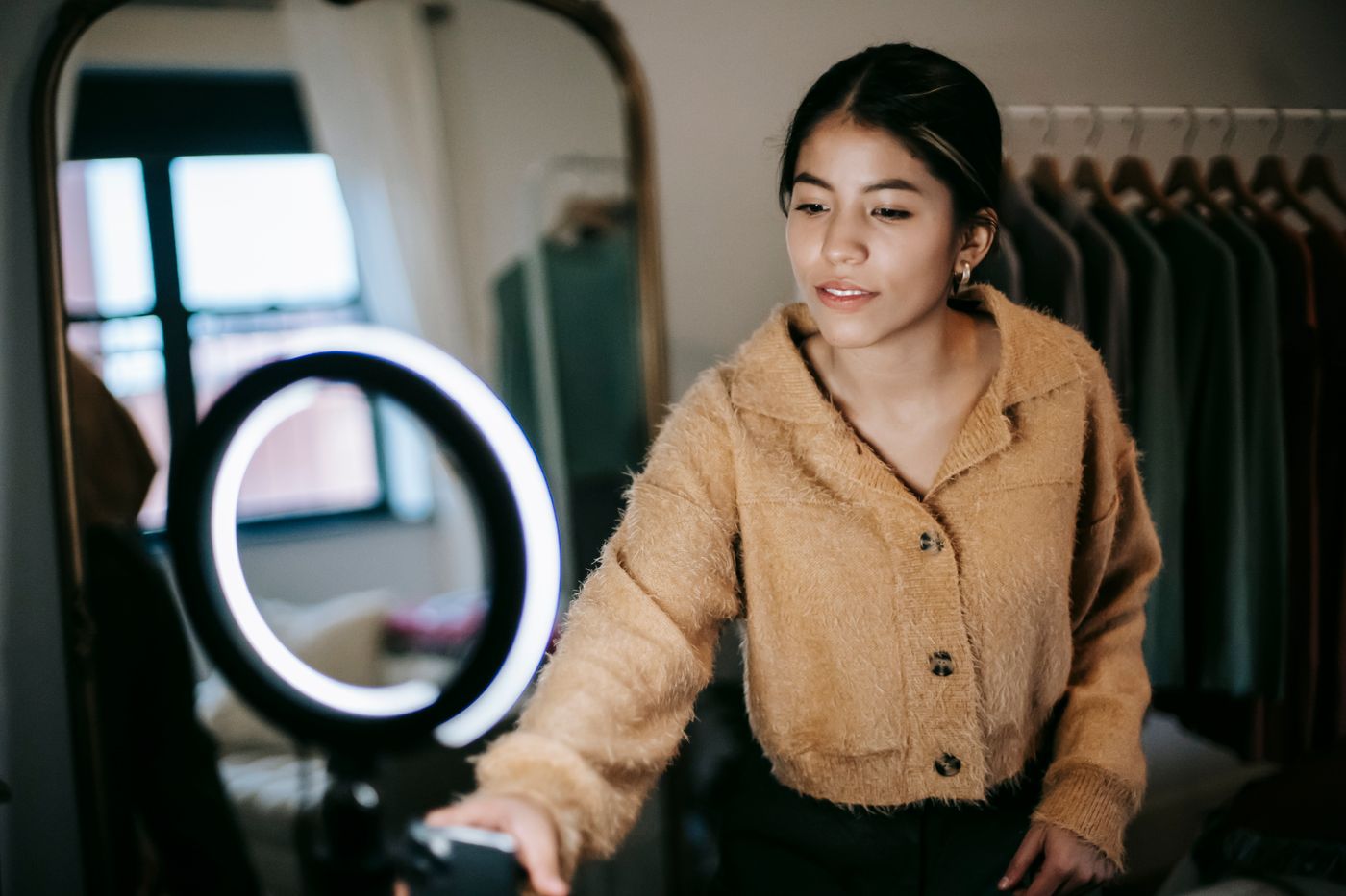 Creator recording social media video with a smartphone and ring light at home
