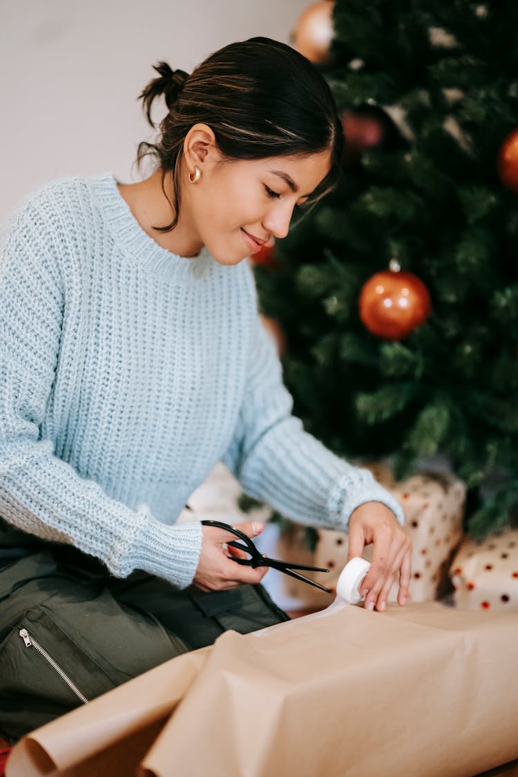 Smiling Ethnic Craftswoman Wrapping Gift Box In House