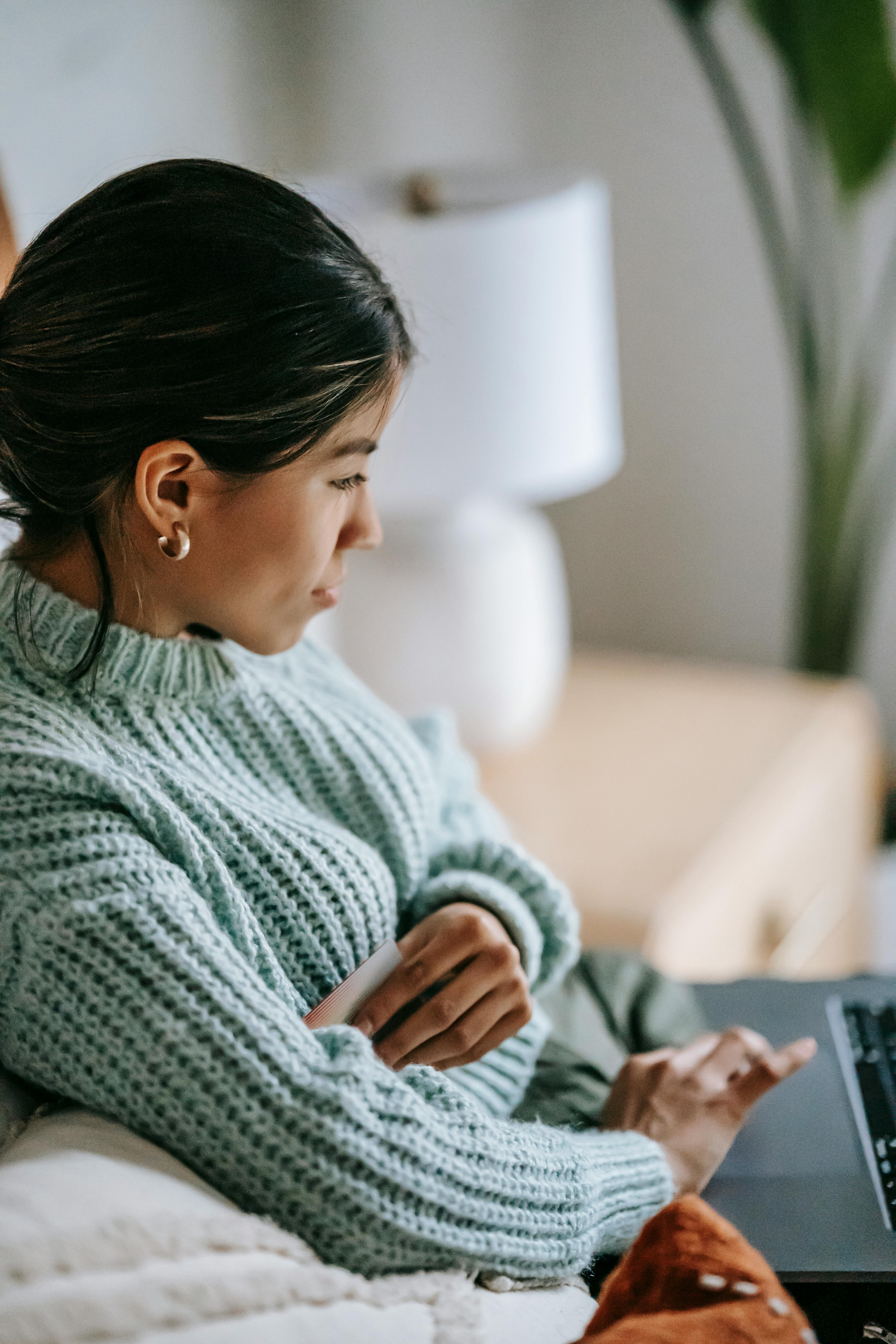 ethnic woman surfing internet on laptop at home