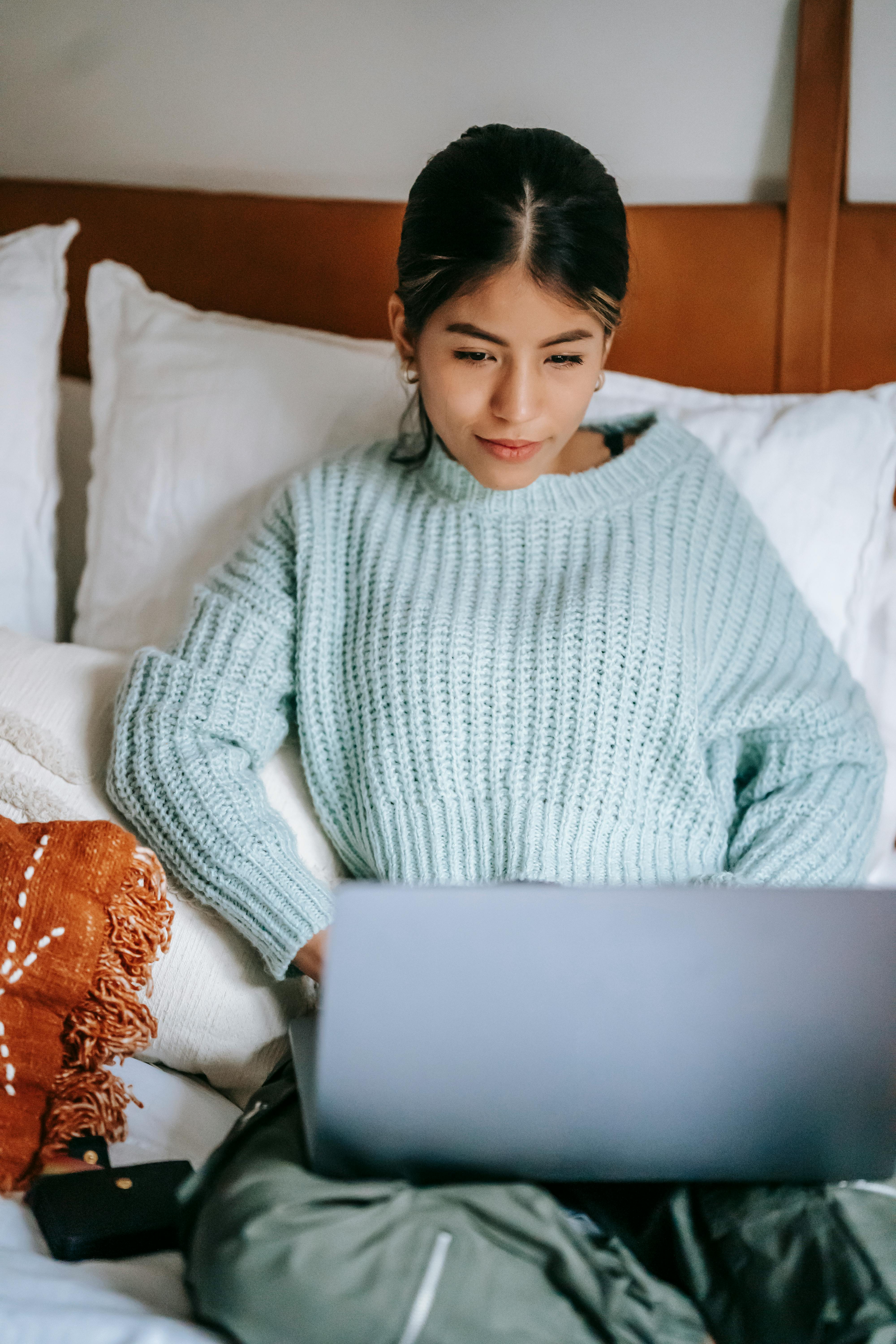 interested ethnic woman surfing internet on laptop at home