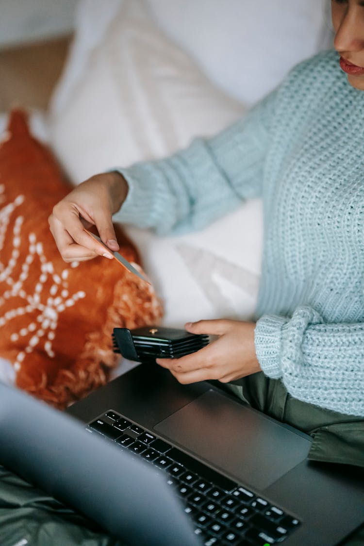 Crop Shopper With Credit Card And Laptop On Bed