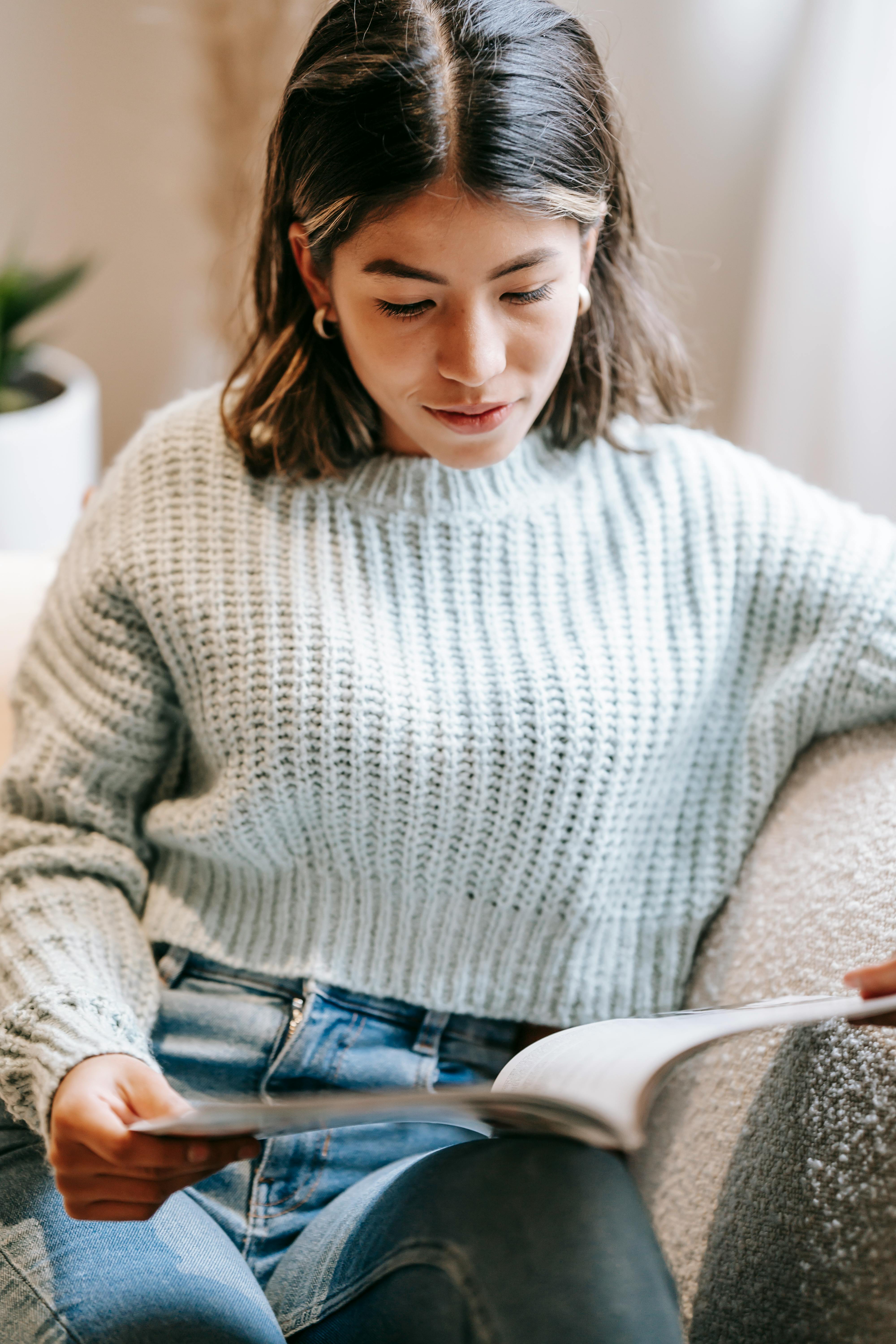 serious woman reading magazine at home