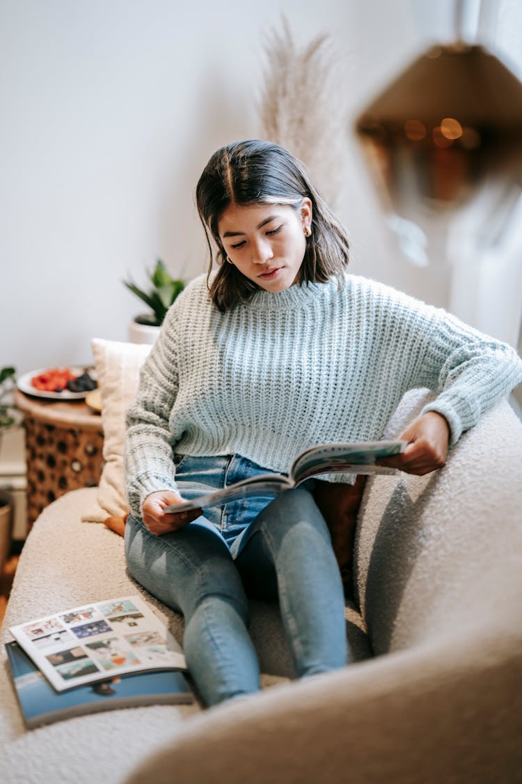 Focused Ethnic Woman Reading Article In Magazine