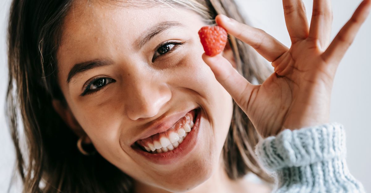 Woman Holding Raspberry Happy ethnic woman showing raspberry in hand · Free Stock Photo