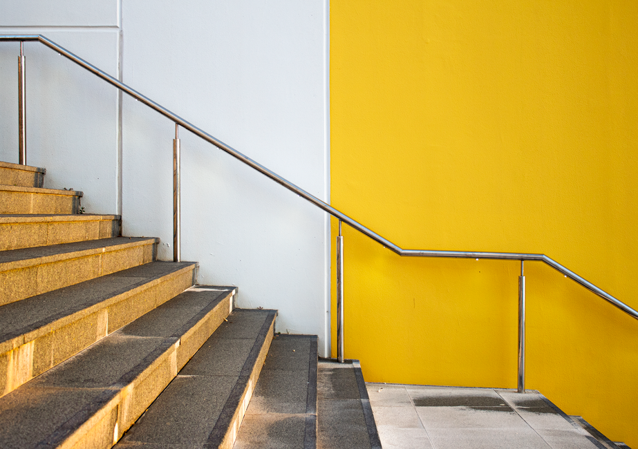 Minimalist staircase design featuring a bright yellow accent wall.