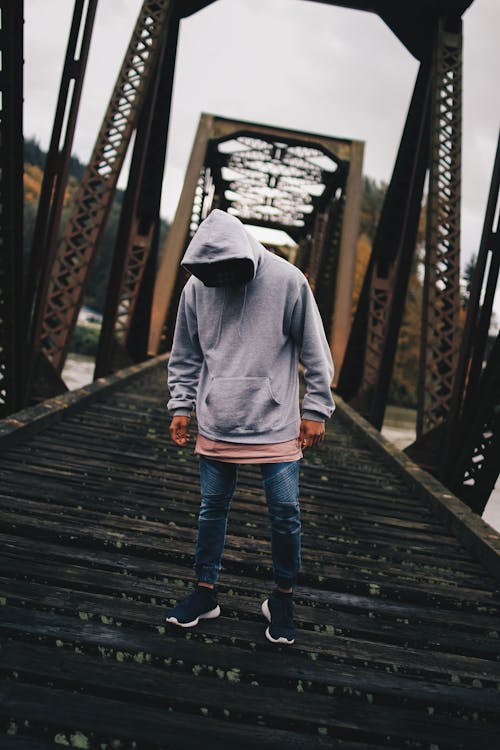 Man in Gray Pull-over Hoodie Standing on Train Rail