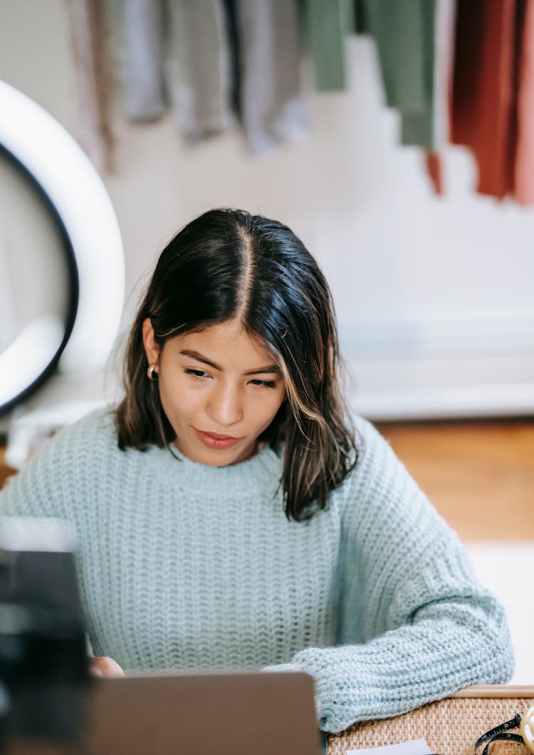 Hispanic Female Freelancer Using Netbook Near Ring Light At Home