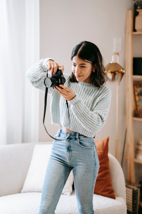 Latin American lady taking photo on photo camera at home