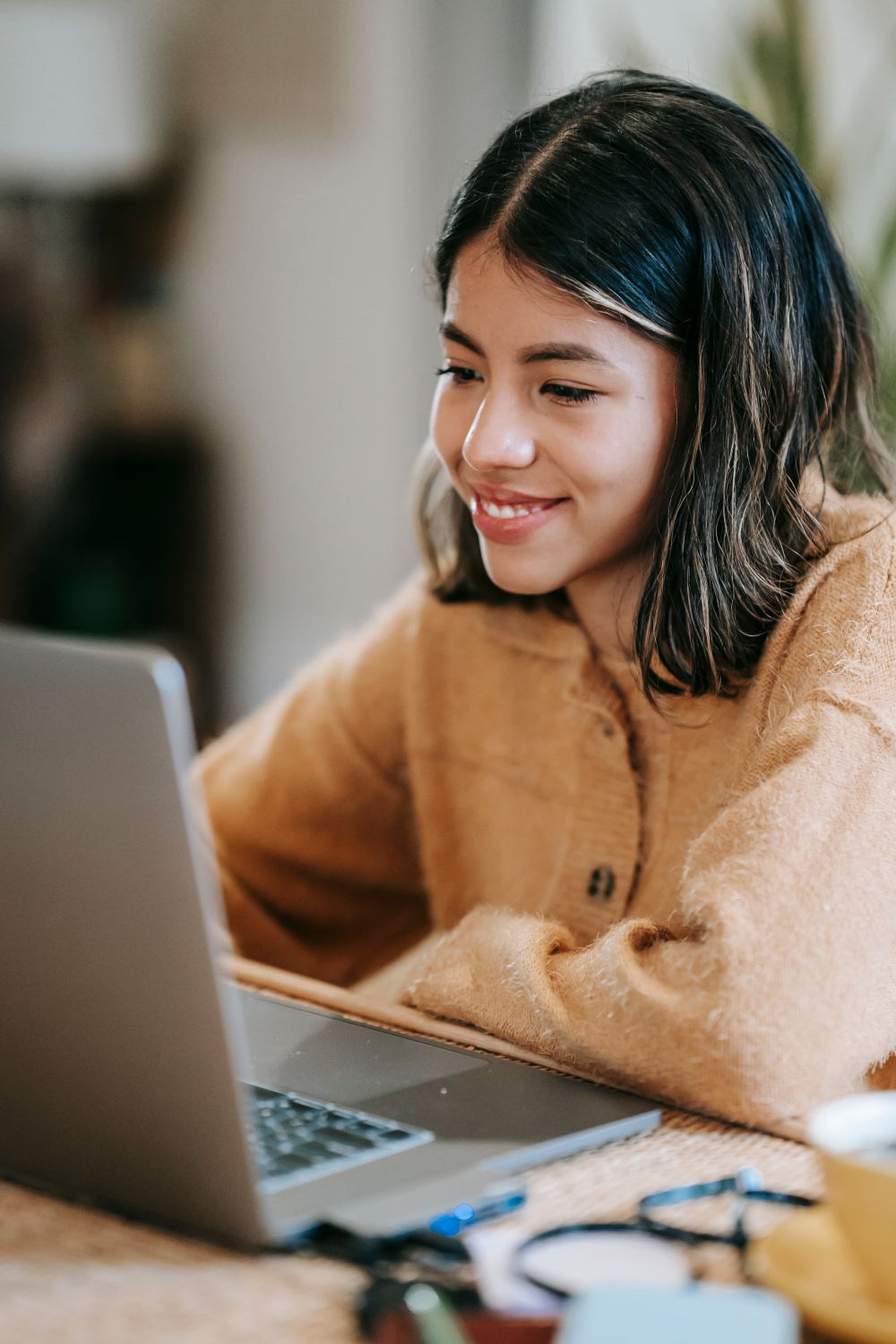 A customer smiling while using a laptop — photo by Liza Summer on Pexels