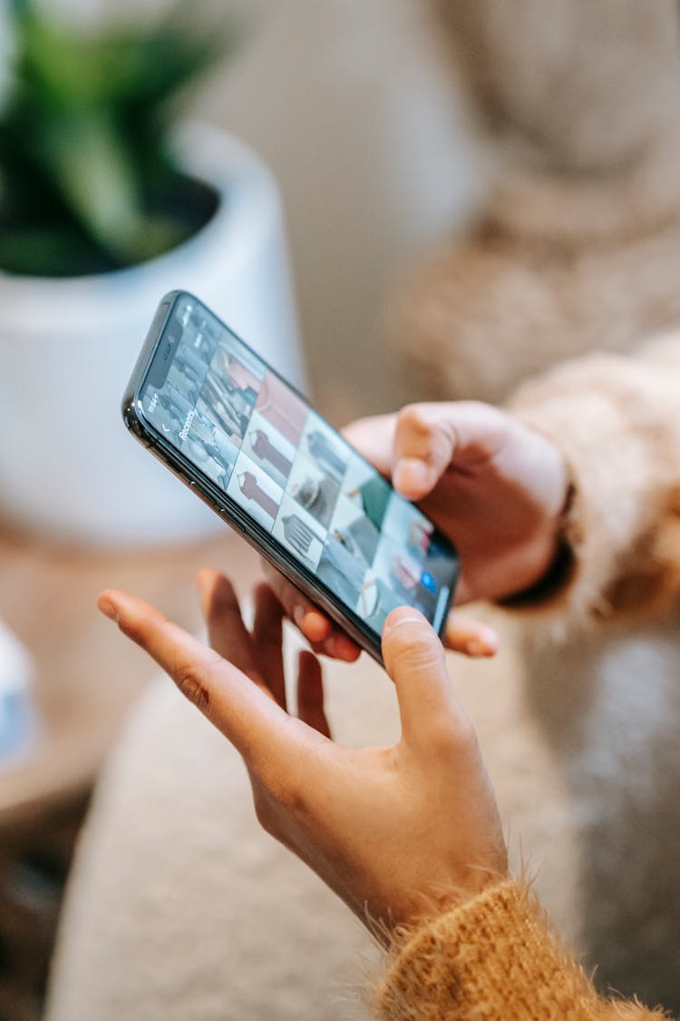 Crop Woman Showing Photo Gallery On Smartphone Screen