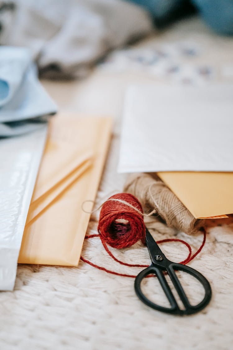 Shipping Parcel Bags Near Scissors And Balls Of Thread