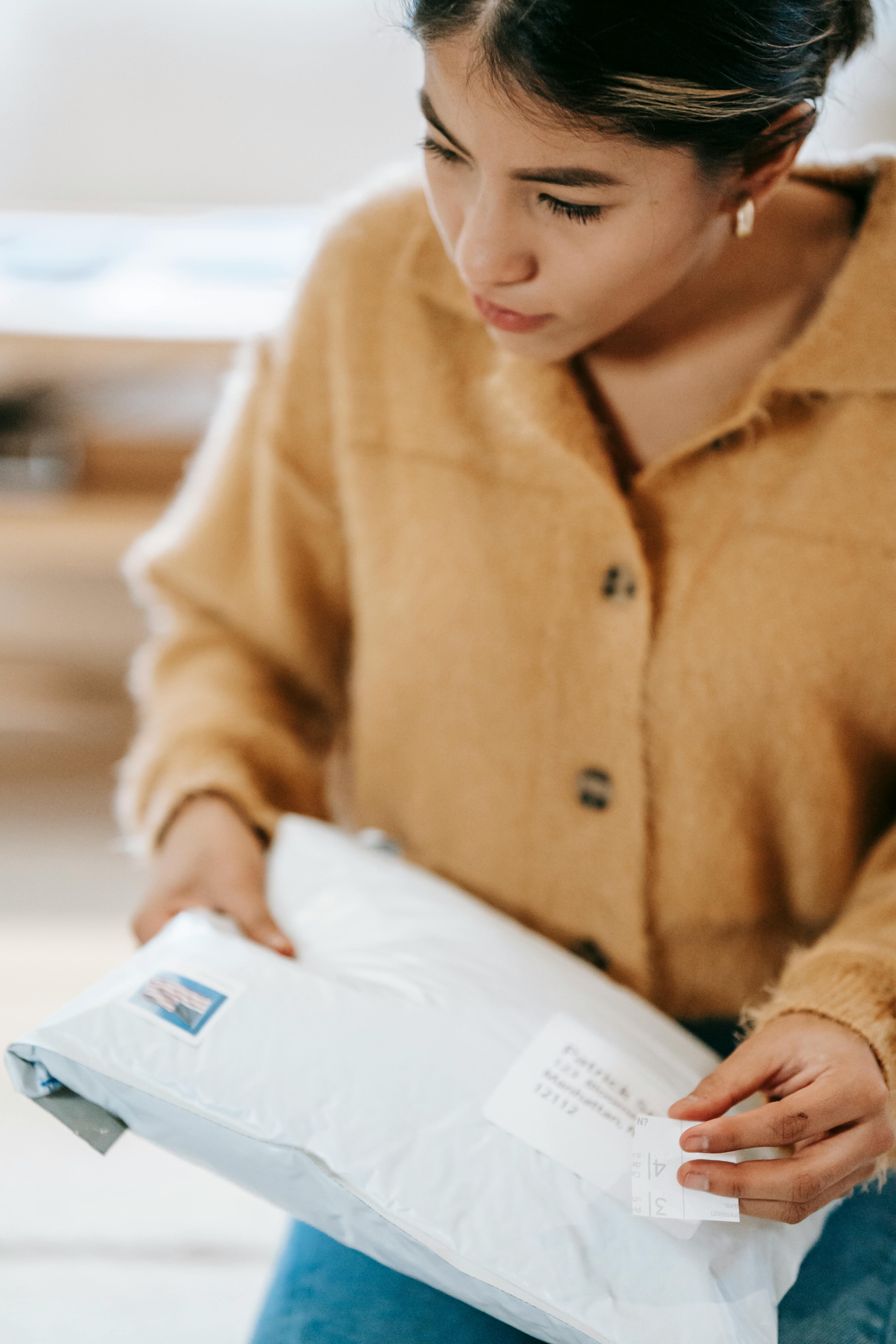 woman in yellow cardigan holding white parcel