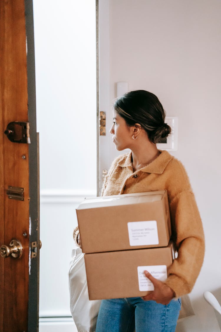 Young Asian Woman With Carton Boxes Leaving Apartment