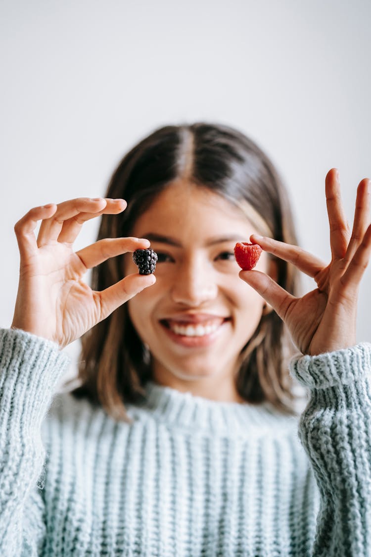 Glad Ethnic Woman Smiling And Showing Raspberry And Blackberry