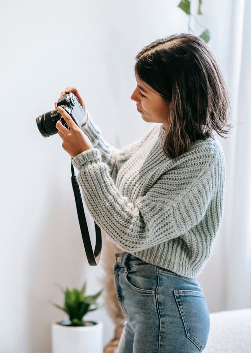Free Side view of young professional photographer taking photos with contemporary photo camera in daytime Stock Photo
