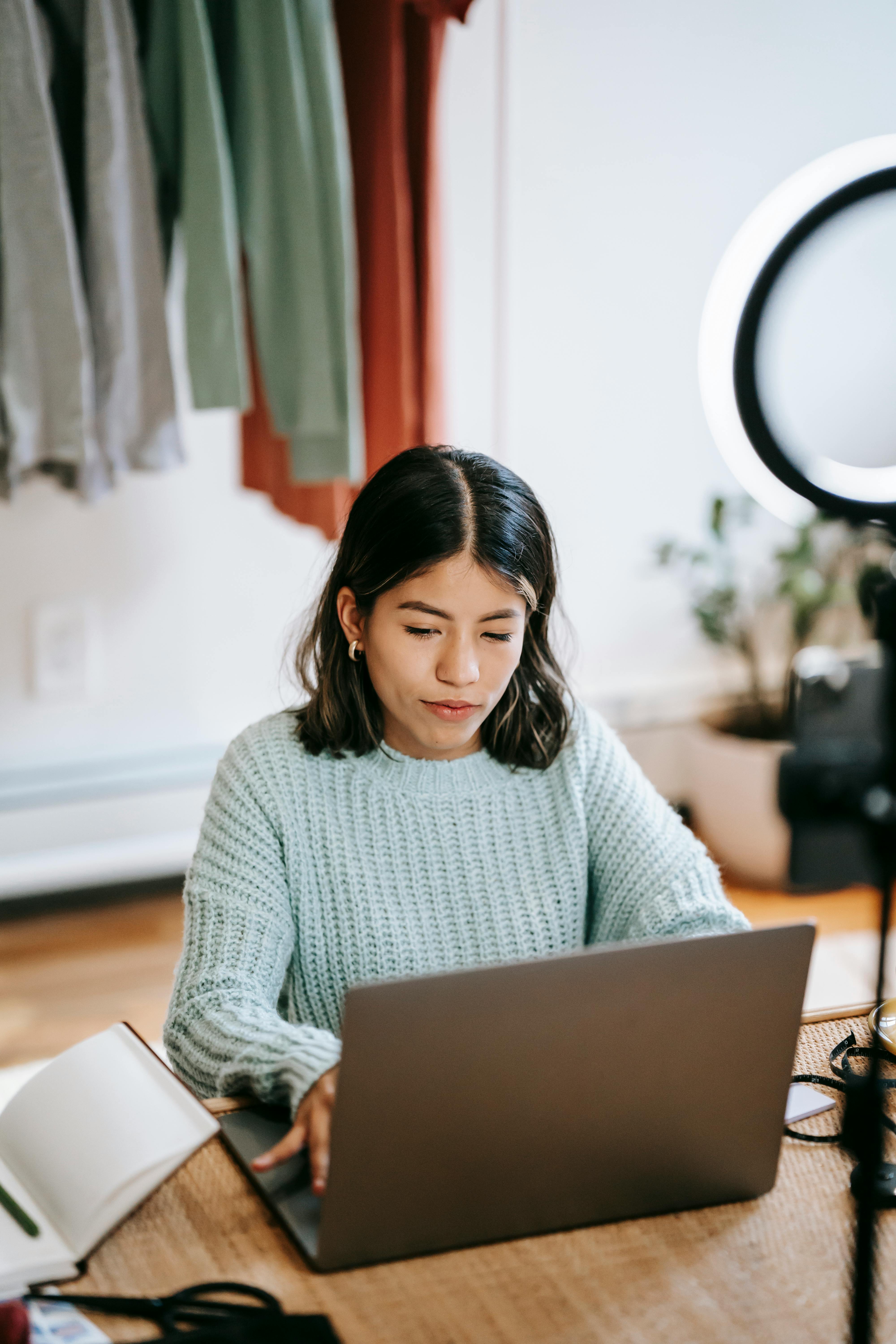 young ethnic woman browsing internet on laptop