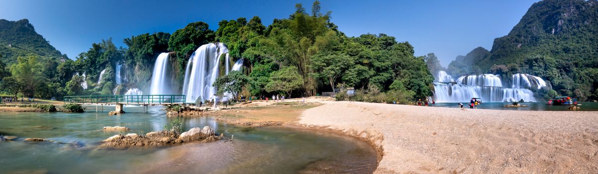 Beautiful view of Ban Gioc Waterfall surrounded by lush jungle and clear water.