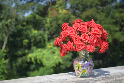 Free Artificial Roses in Clear Glass Vase on Concrete Surface Stock Photo