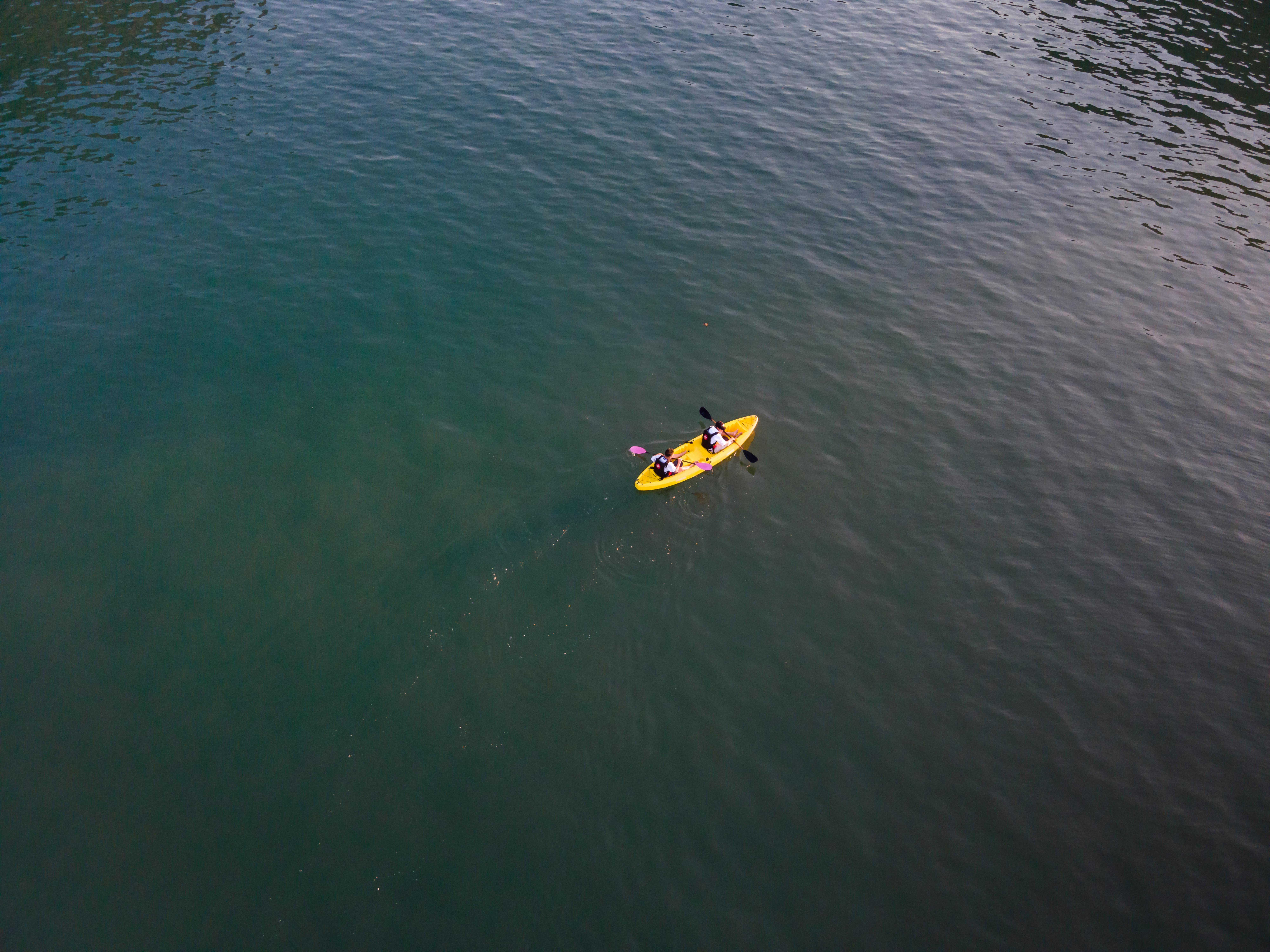 Aerial view of two kayakers paddling on calm, open water, enjoying a peaceful outdoor adventure.