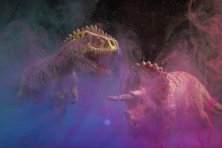 Dinosaur Toys In A Cloud Of White Ink Underwater