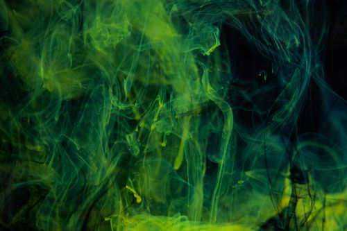 Free Green and yellow ink swirls create an abstract design on a dark background, perfect for unique wallpaper. Stock Photo