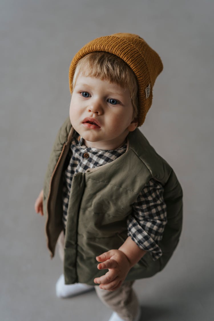 A Boy Wearing A Knit Cap And A Vest