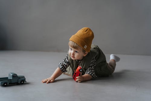 Free A Good Looking Toddles Crawling on the Floor with a Toy  Car Stock Photo