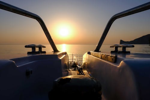 Free Amazing sunset over sea with sailing boat Stock Photo