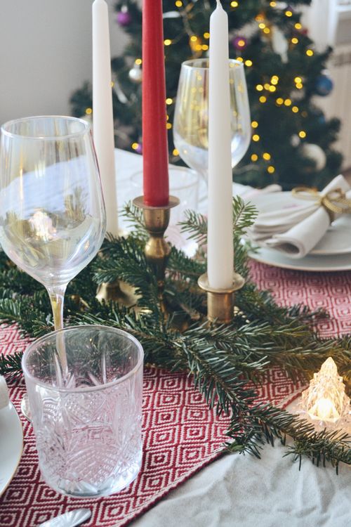 Free Close-up of a luxurious festive table setting adorned with candles and Christmas decor. Stock Photo