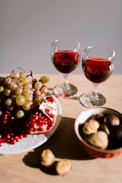 Red Wine in Clear Wine Glass Beside the Nuts and Fruits