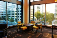 现代酒店休息室的黄色椅子旁，透过大窗户可以欣赏城市景观