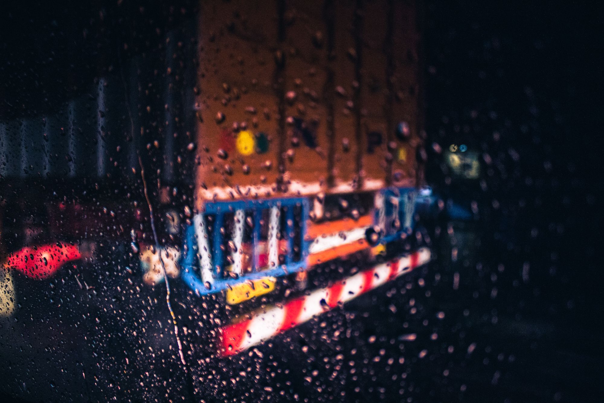Parabrisas de un vehículo bajo lluvia intensa durante la noche en una carretera
