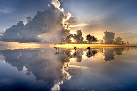 Fishermen silhouetted against a stunning sunset with dramatic clouds reflecting on the ocean surface.