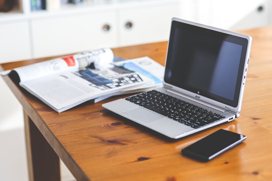 A sleek home office setup with a laptop and smartphone on a wooden desk, ideal for productivity.