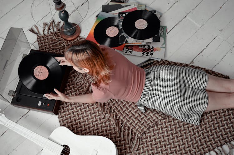 Faceless Woman Putting Vinyl Record On Player On Floor