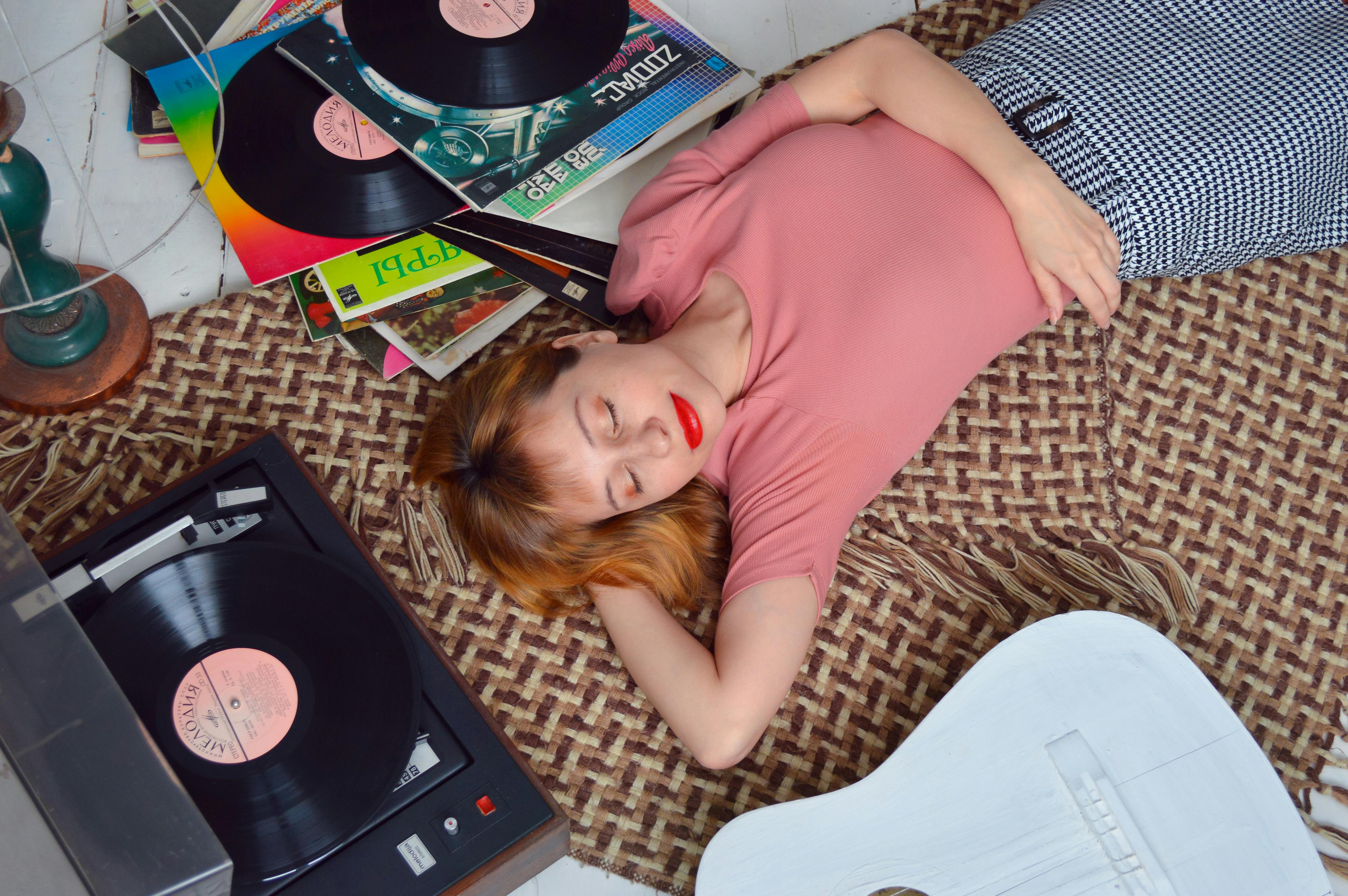 relaxed woman lying on floor near vinyl record player