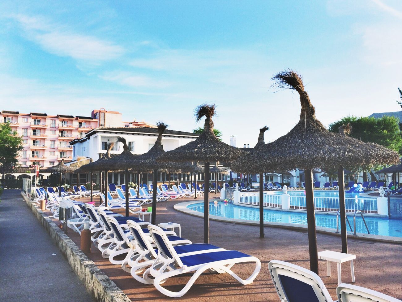 Palm-lined swimming pool and loungers at a beach resort on the Mombasa north coast