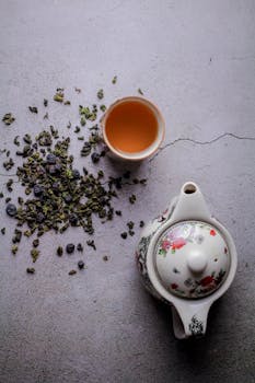 A beautifully composed top view of oolong tea with a decorative teapot and loose tea leaves.