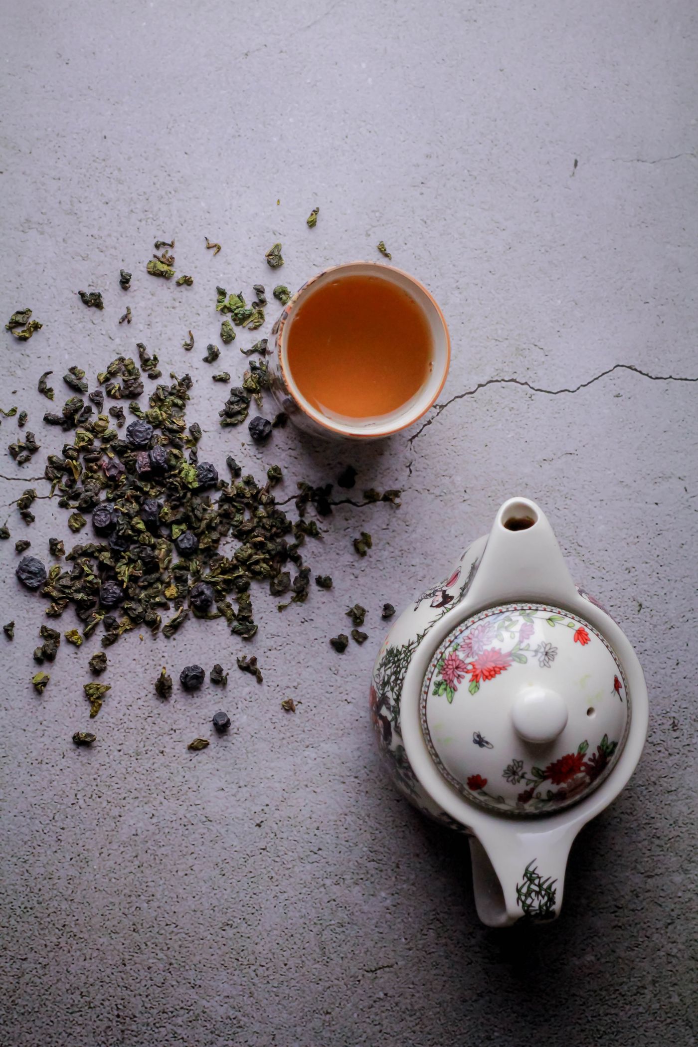 Top view of oolong tea leaves and a decorative teapot.