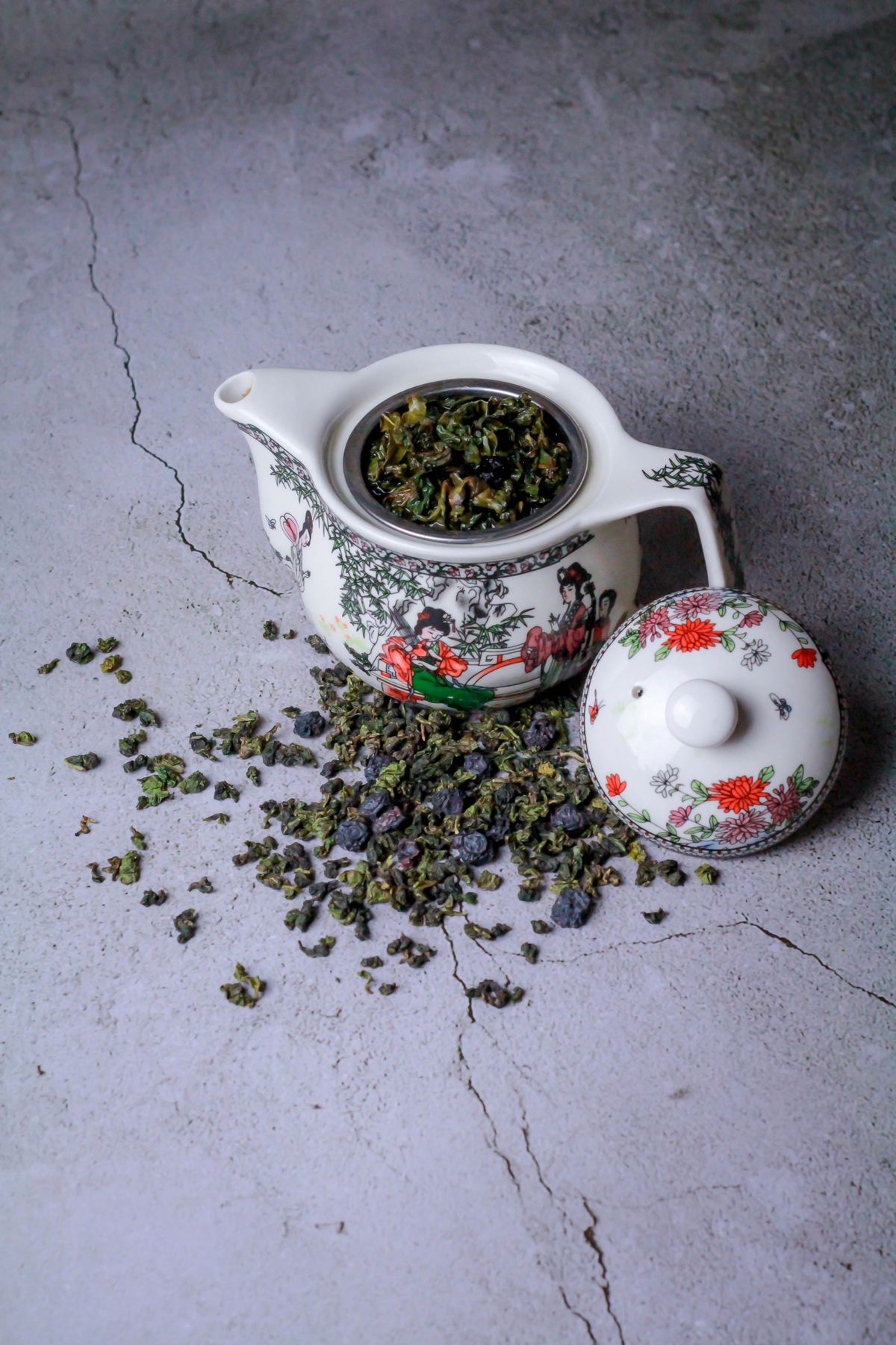 Oolong tea leaves beside a ceramic teapot — visual inspiration for White Peach Oolong Tea