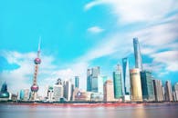 在明亮的蓝天下，上海令人惊叹的天际线映衬着标志性的东方明珠塔和现代摩天大楼