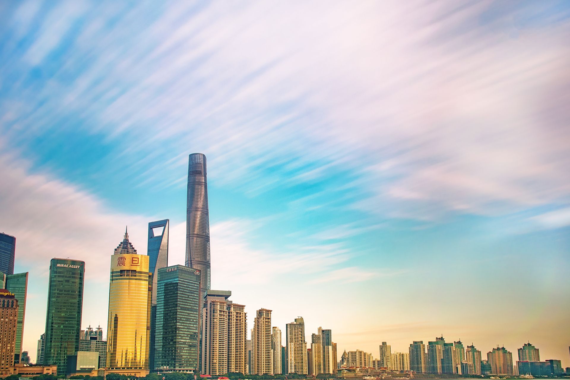 Shanghai skyline featuring iconic skyscrapers against a colorful dawn sky. Ideal for urban and architecture themes.