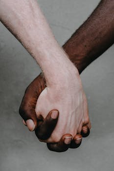 A close-up of diverse hands holding, symbolizing unity and friendship.
