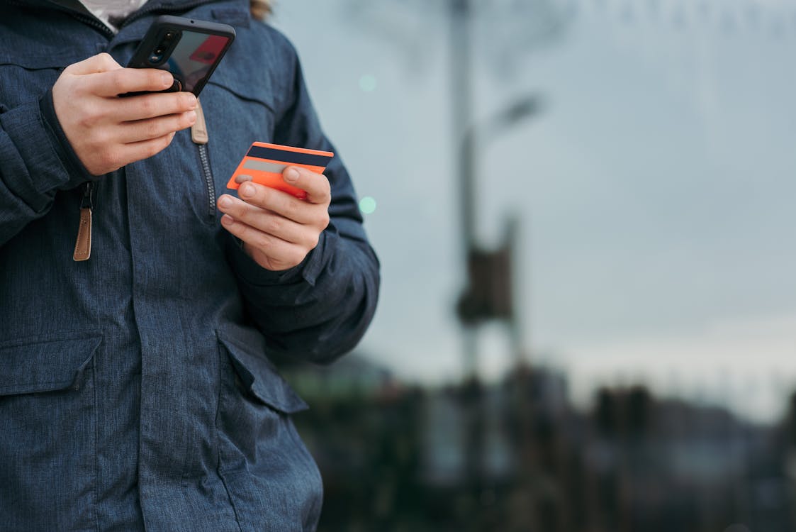 Persona En Chaqueta Negra Con Smartphone Negro