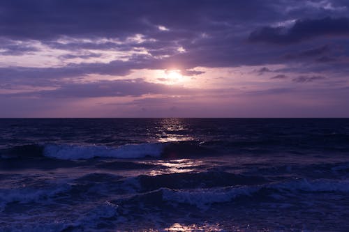 бесплатная Фотография Голубого океана и темных облаков во время заката Стоковое фото