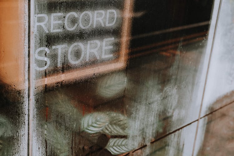 Signboard With Inscription Record Store Against Glass Wall